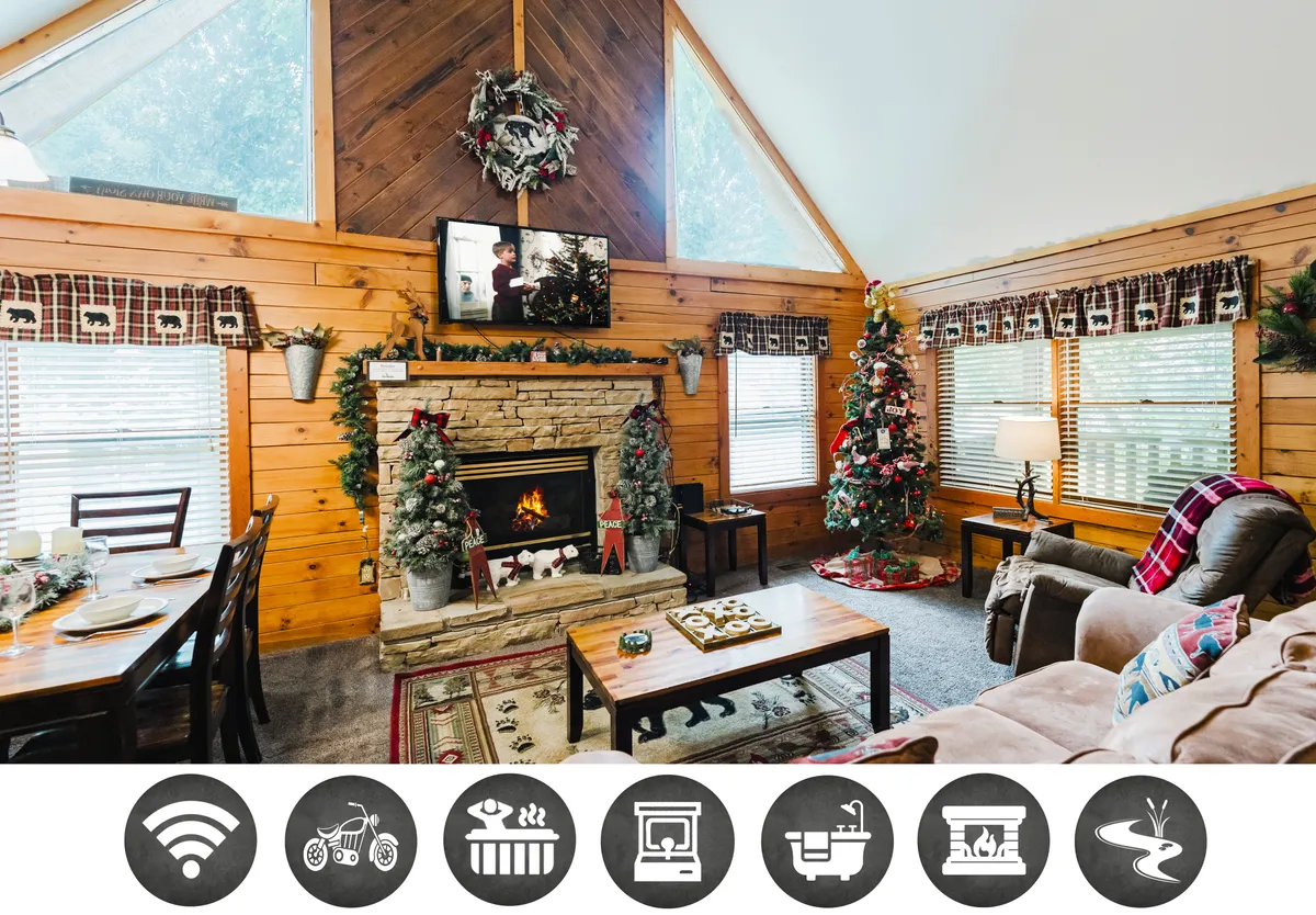 The image showcases a warm and inviting cabin interior with a glowing fireplace, a beautifully decorated Christmas tree, and a spacious dining table set for holiday meals. The scene exudes a festive atmosphere perfect for family gatherings and holiday celebrations, with cozy seating areas encouraging relaxation by the fire.